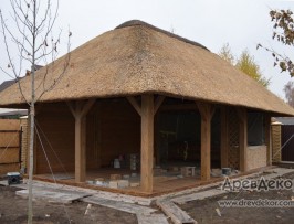 Состаренная беседка под соломенной крышей